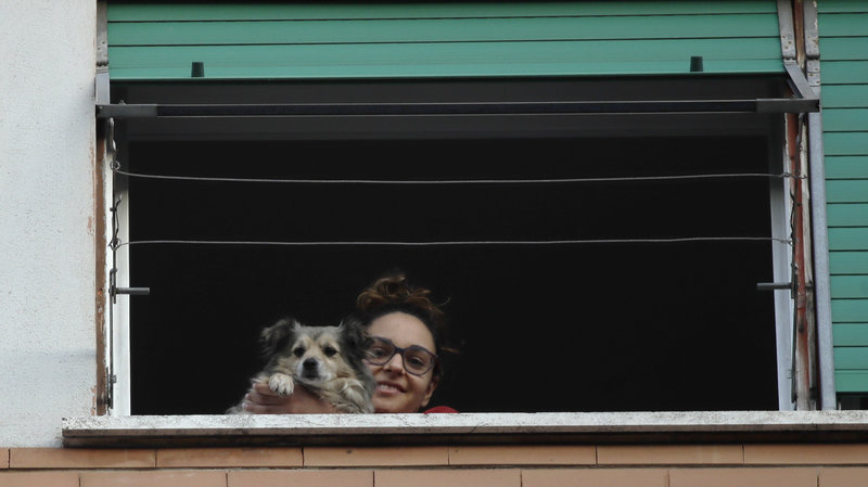 A girl and her dog look out from a window during one of the many flash mobs taking place in Rome, on Sunday.